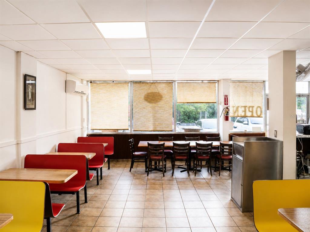 A restaurant dining room features red booths, wooden tables, chairs, and large windows with blinds — #2 St. CARR. JUAQUIN “YIYE” AVILA, QUEBRADILLAS, PR