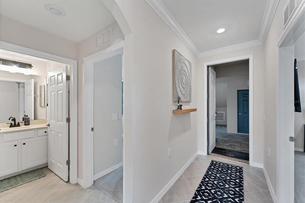A hallway with light tile flooring leads to a bathroom, a closet, and an entryway — 17704 GAWTHROP DRIVE UNIT 102, BRADENTON, FL