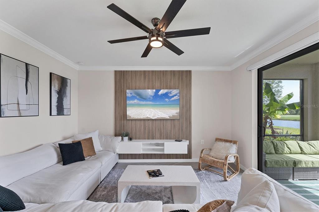 A living room features a slatted wood accent wall, a white floating console, and sectional seating — 17704 GAWTHROP DRIVE UNIT 102, BRADENTON, FL