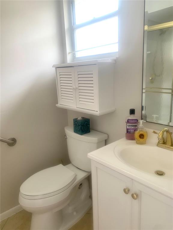 A bathroom features a white vanity, a toilet, a wall-mounted cabinet, and a window — 2310 CANALBLUFF PLACE UNIT V287, SARASOTA, FL