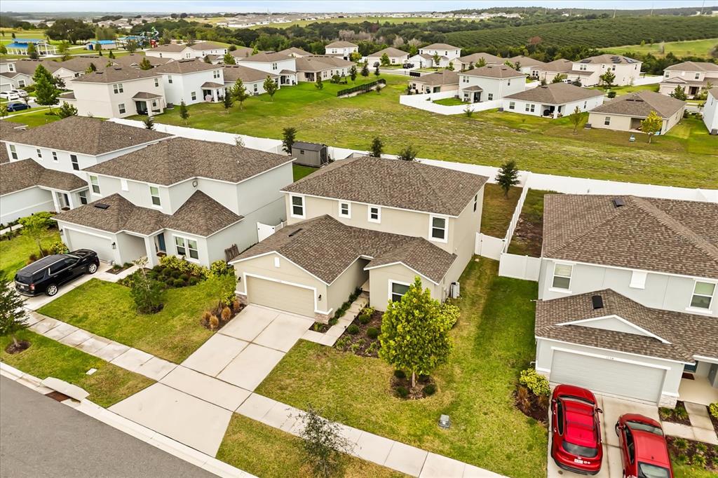 An aerial view shows several suburban houses with driveways, lawns, and a surrounding neighborhood landscape — 1138 CALICO POINTE CIRCLE, GROVELAND, FL