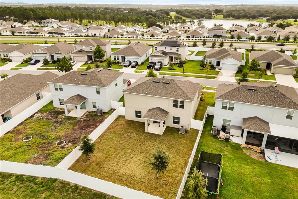 An aerial view shows the backyards and rear exteriors of several suburban houses — 1138 CALICO POINTE CIRCLE, GROVELAND, FL