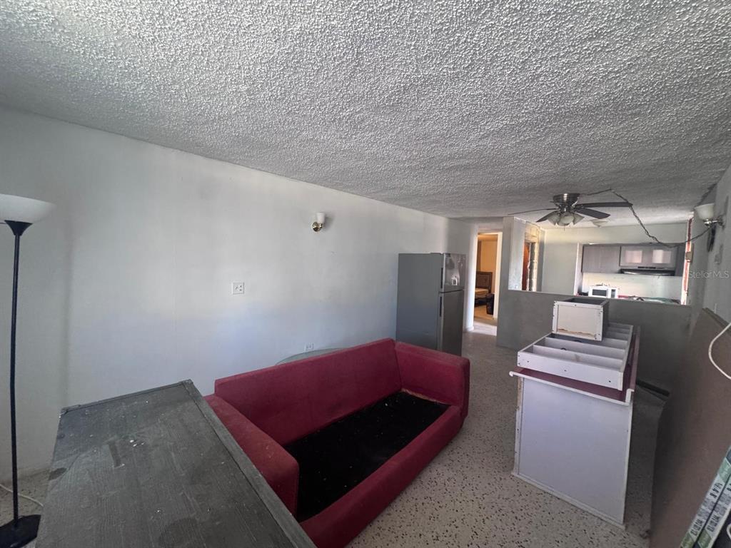 A living room with a red sofa, a refrigerator, and a kitchen pass-through window — 2S-2 URB METROPOLIS, CAROLINA, PR