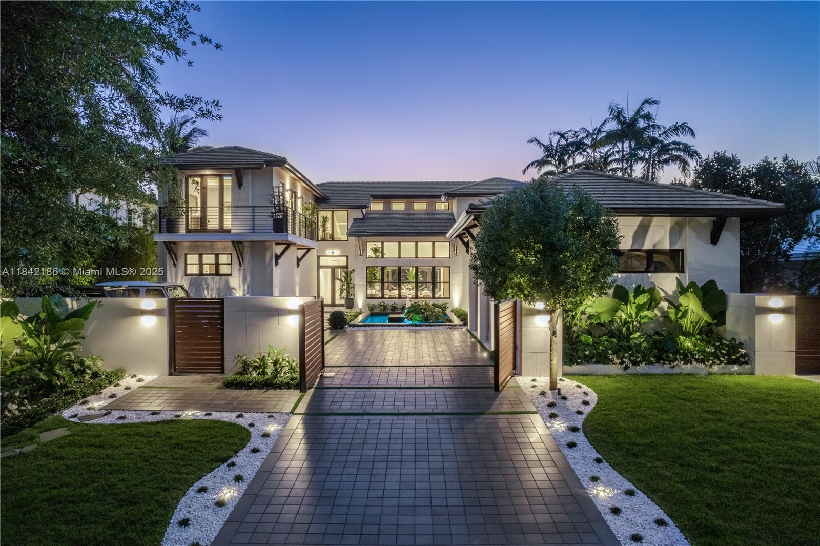 A modern two-story house features a paved driveway, a gated entrance, and a small fountain — 4241 Palm Ln, Miami FL 33137, MIAMI, FL