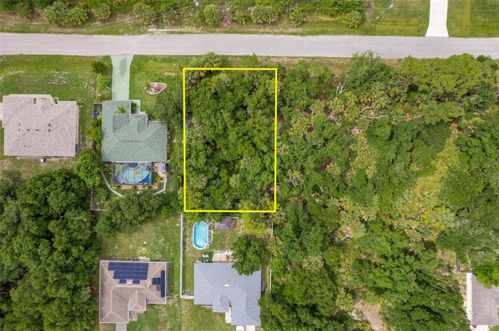 An aerial view shows a rectangular vacant lot outlined in yellow surrounded by wooded areas — VAN LEER AVENUE, NORTH PORT, FL