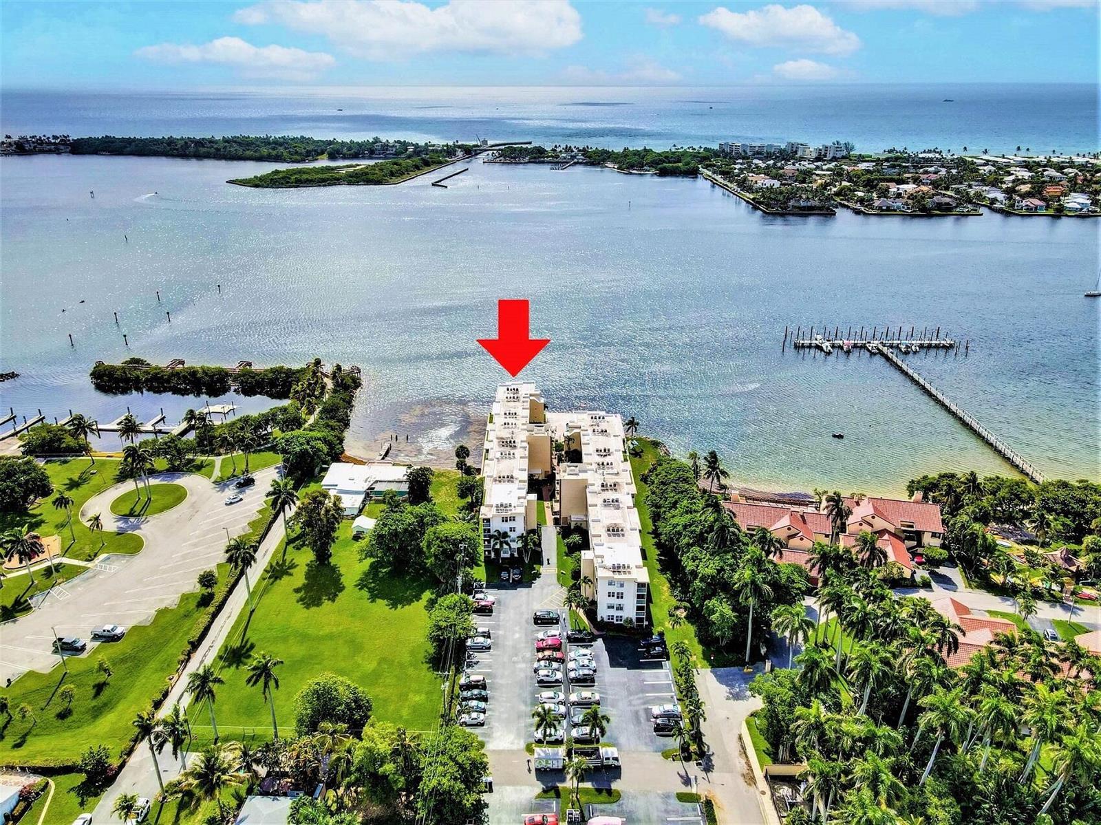 An aerial view shows a waterfront apartment complex with a parking lot and boat docks — 1820 New Palm Way # 201, Boynton Beach FL 33435, BOYNTON BEACH, FL