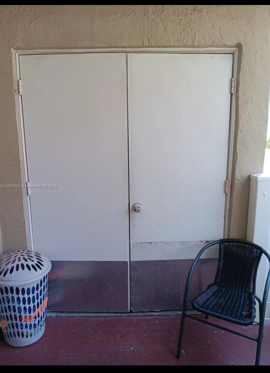 A pair of white double doors with metal kick plates sits on a balcony — 18870 NW 57th Ave # 108, Hialeah FL 33015, HIALEAH, FL