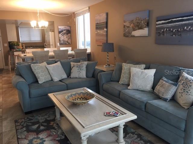 A living room features two blue sofas, a coffee table, and wall art — 421 SOUTH ATLANTIC AVENUE UNIT 806, NEW SMYRNA BEACH, FL