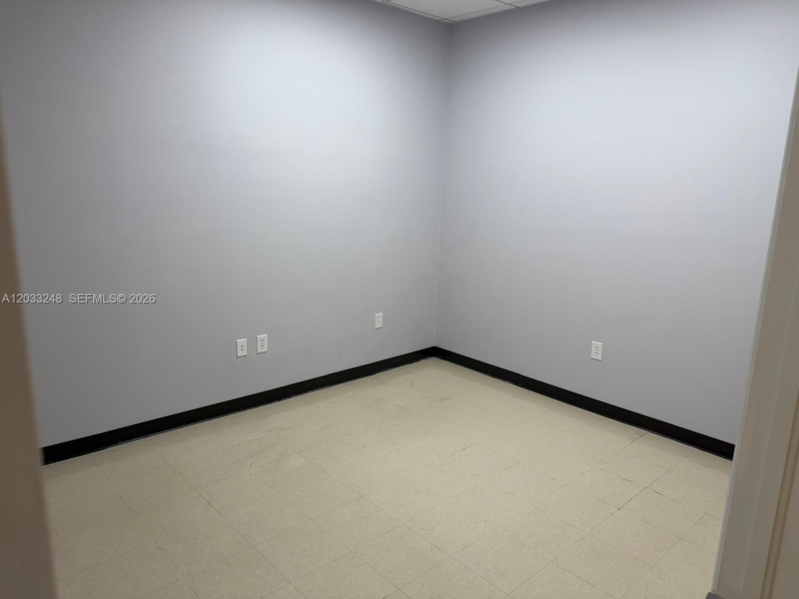 An empty room features light gray walls, beige tile flooring, and black baseboards — 8688 NW 44 ST, Sunrise FL 33351, SUNRISE, FL