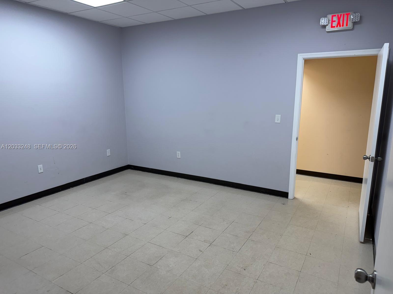 An empty office room features gray walls, a tiled floor, and an open doorway — 8688 NW 44 ST, Sunrise FL 33351, SUNRISE, FL