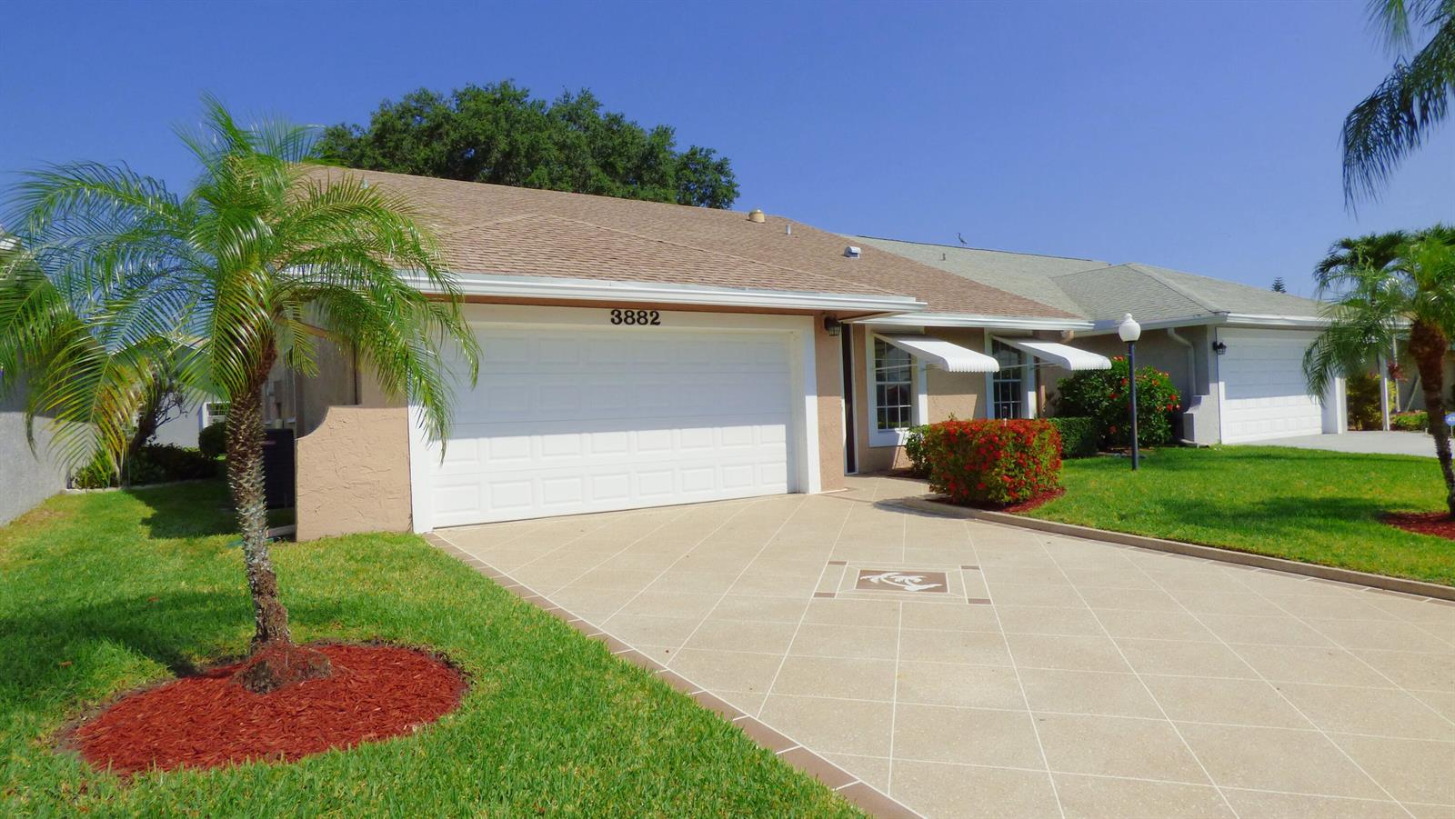 A single-story house with a beige stucco exterior, a two-car garage, and a palm tree — 3882 Dafilee Circle, West Palm Beach FL 33417, WEST PALM BEACH, FL