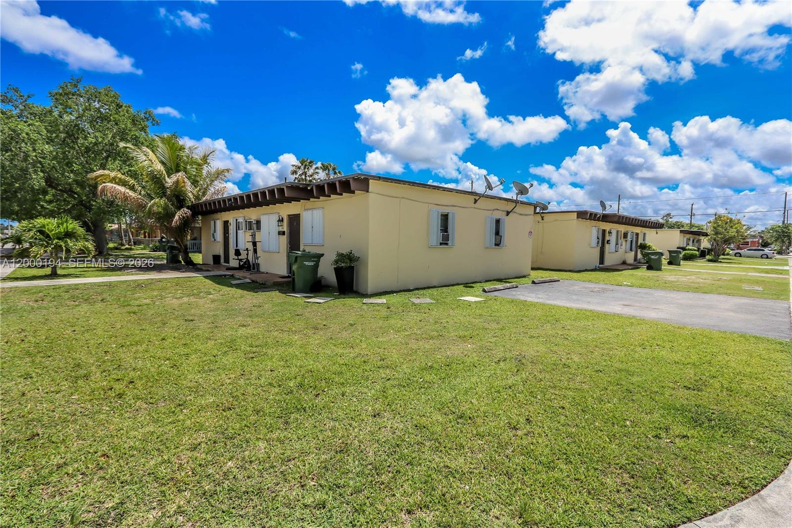 A low-rise, yellow stucco residential building sits on a grassy lot under a cloudy sky — 720 SW 6th St, Homestead FL 33030, HOMESTEAD, FL