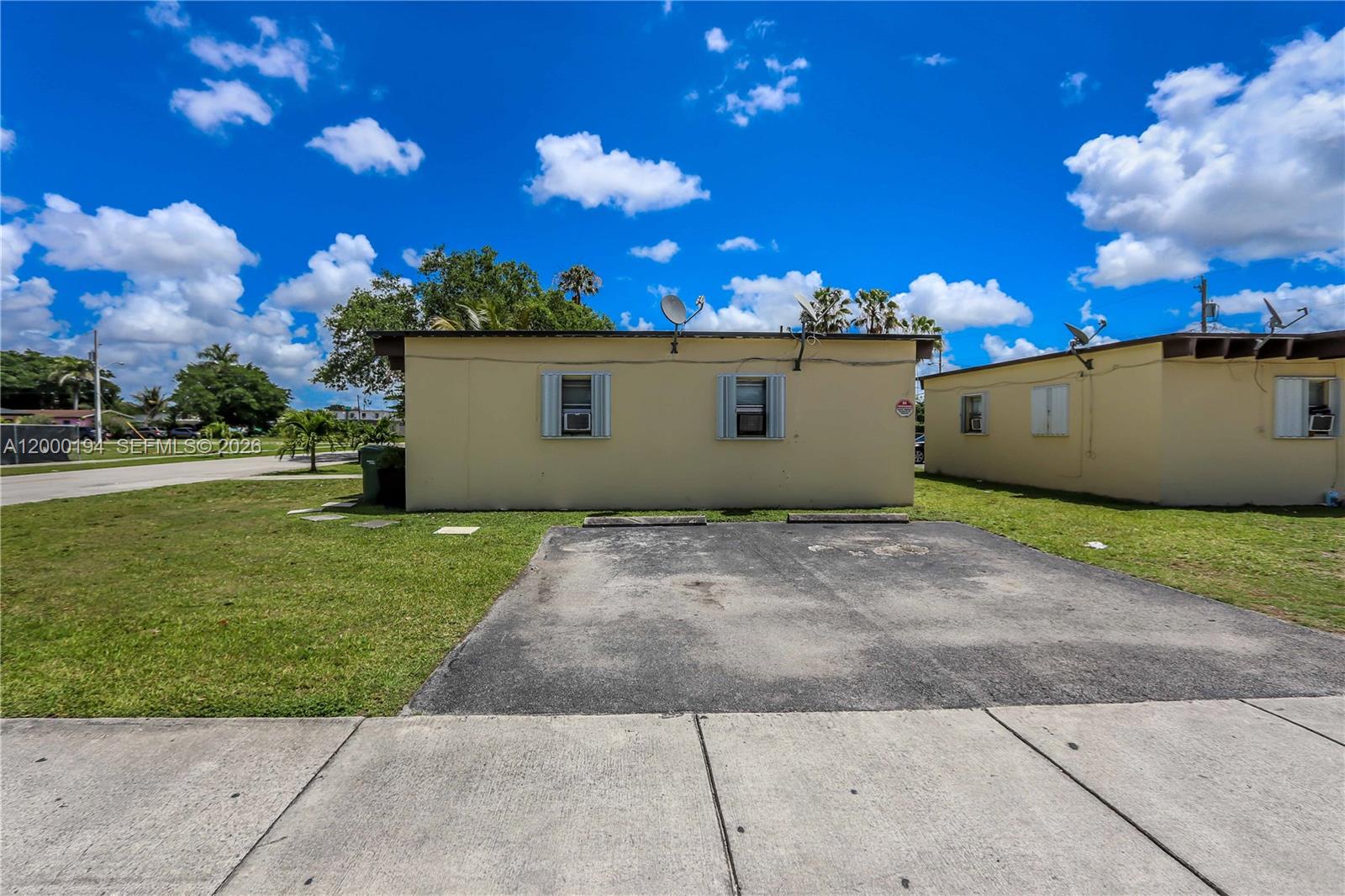 A single-story yellow building features two windows and a paved parking area in front — 720 SW 6th St, Homestead FL 33030, HOMESTEAD, FL