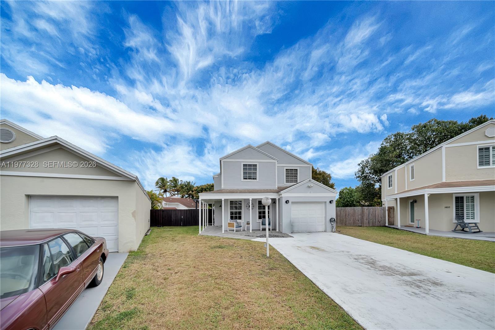 A two-story light gray house with a concrete driveway and a front porch — 14531 SW 127th Ct, Miami FL 33186, MIAMI, FL