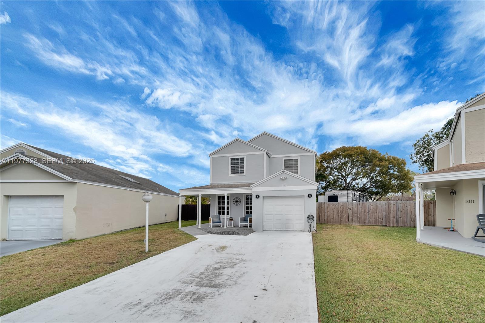 A two-story gray house features a front porch, a garage, and a concrete driveway — 14531 SW 127th Ct, Miami FL 33186, MIAMI, FL