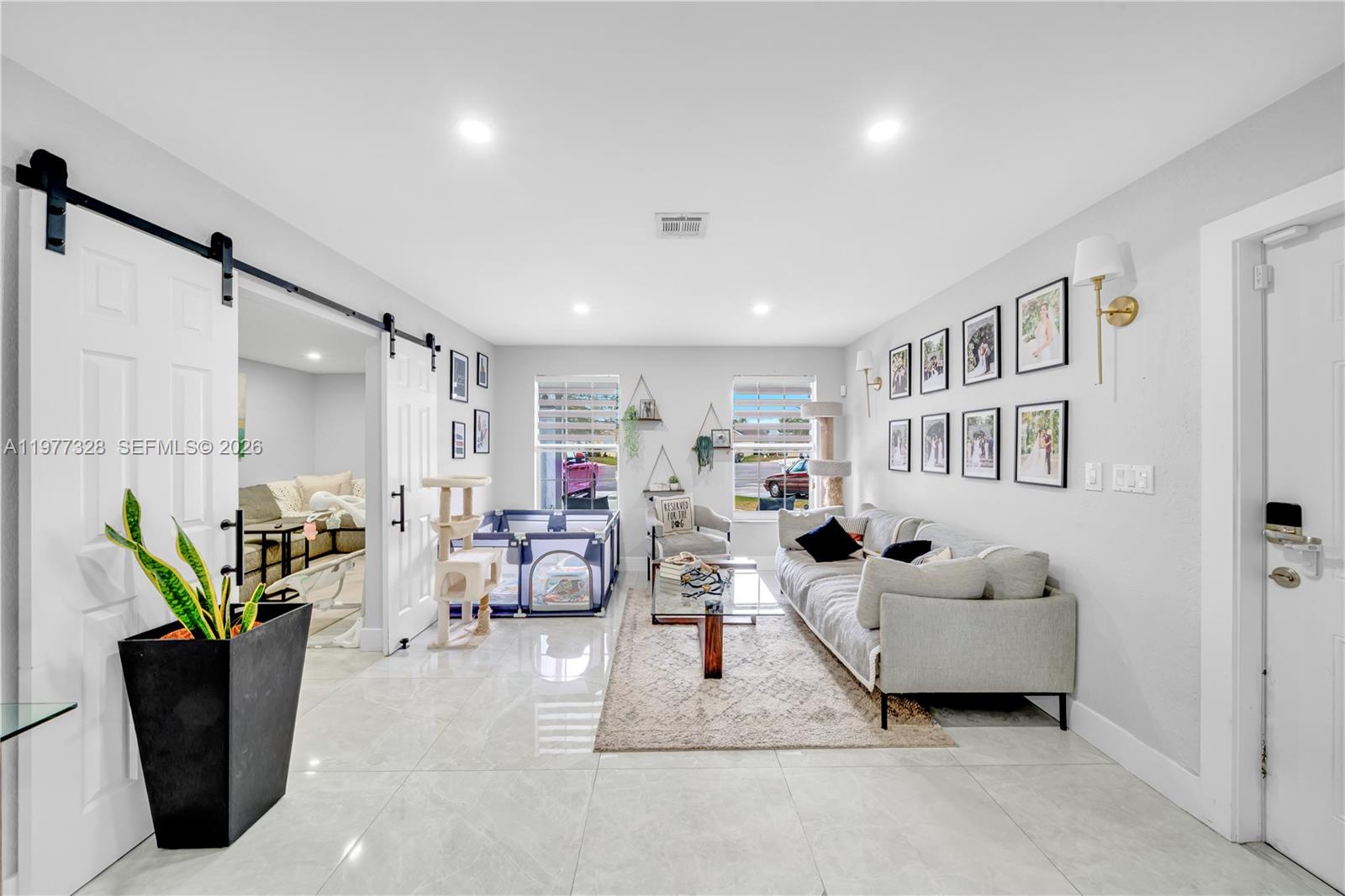 A two-story gray house features a front porch, a garage, and a concrete driveway — 14531 SW 127th Ct, Miami FL 33186, MIAMI, FL