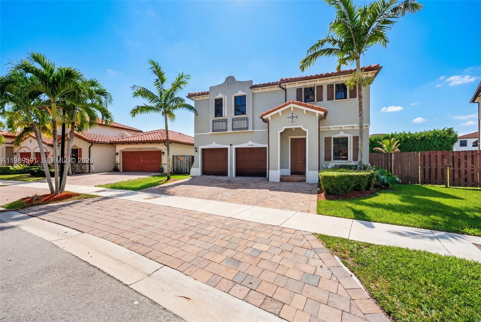 A two-story house with a tiled roof, two garage doors, and palm trees in front — 17340 SW 154th Pl, Miami FL 33187, MIAMI, FL