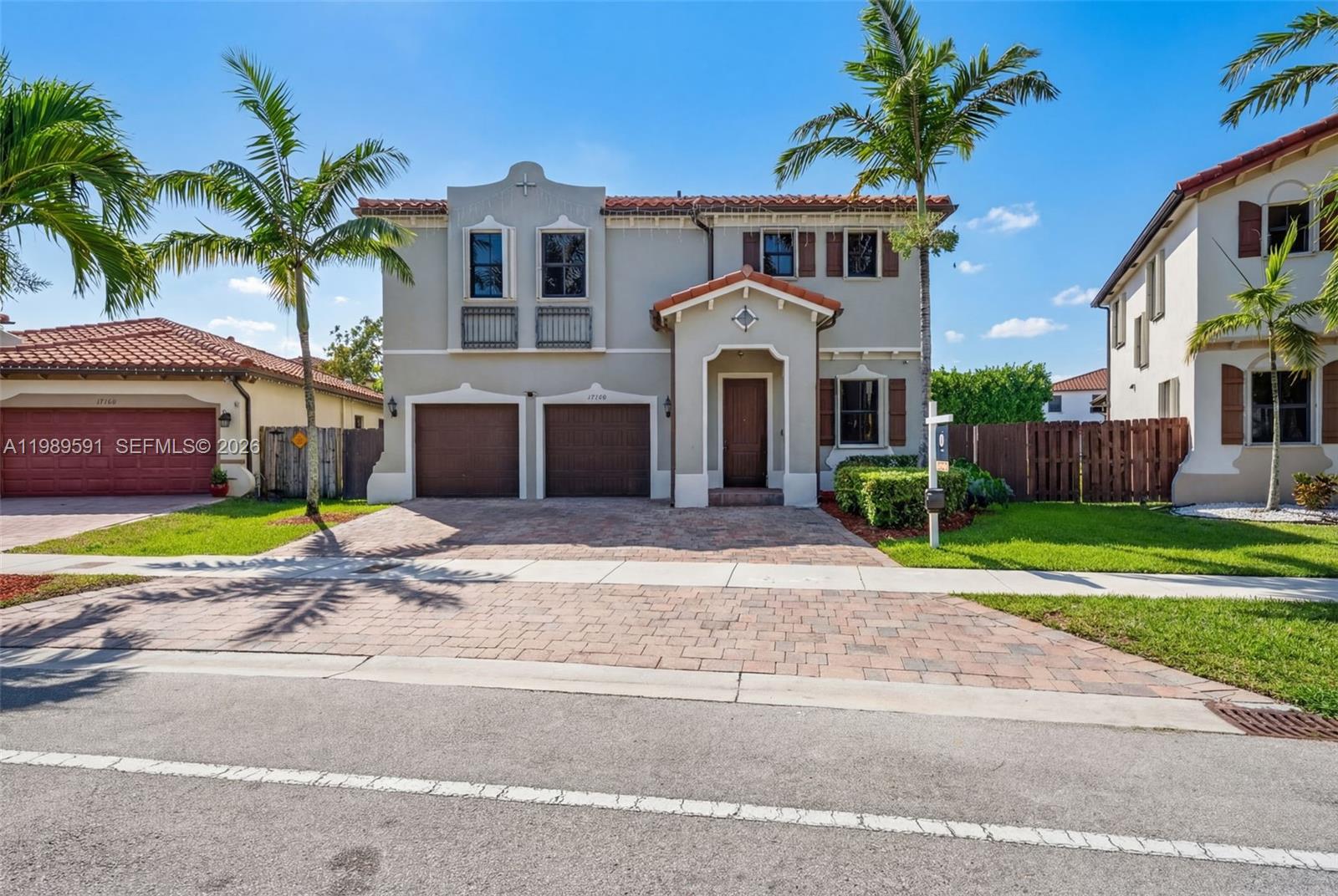 A two-story house with a two-car garage, tile roof, and palm trees in the front yard — 17340 SW 154th Pl, Miami FL 33187, MIAMI, FL