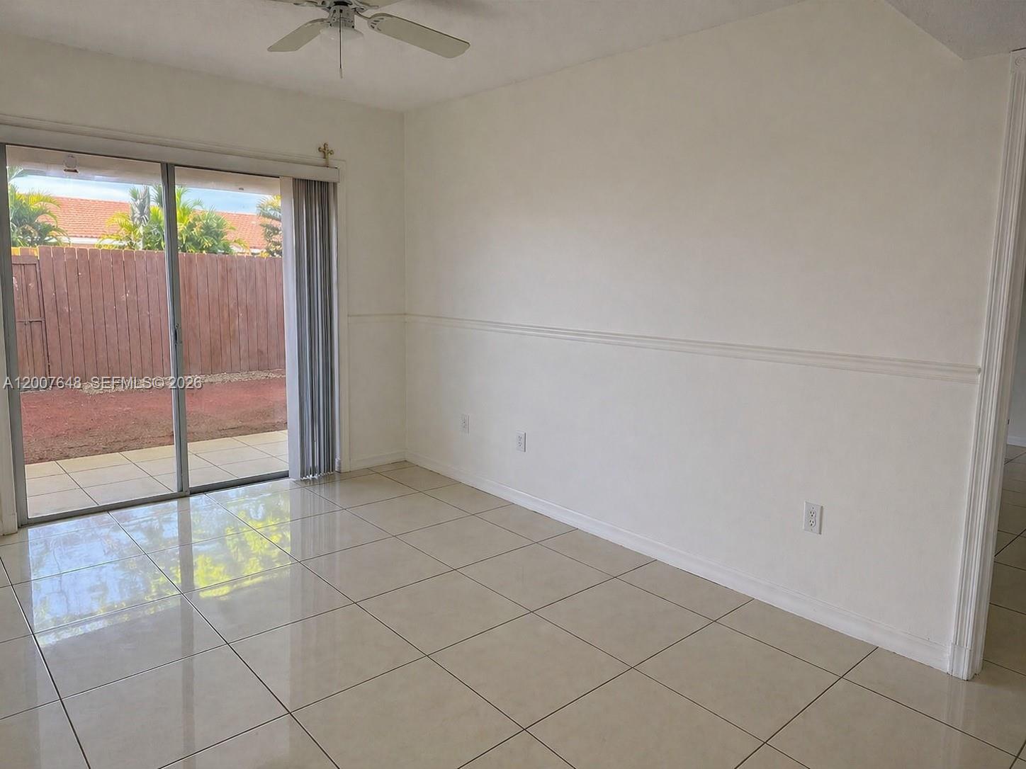 A room with white walls, tile flooring, a ceiling fan, and sliding glass patio doors — 15400 SW 81st Cir Ln # 1011, Miami FL 33193, MIAMI, FL