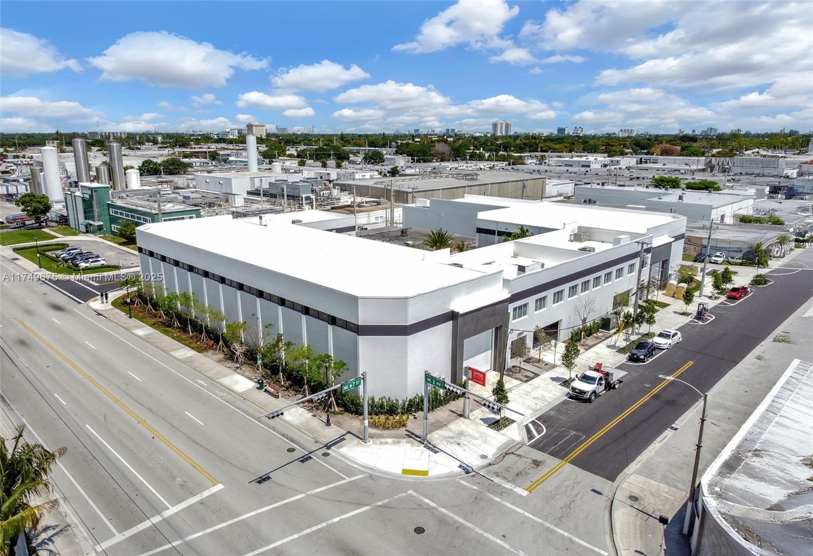 An aerial view shows a white commercial building at a street intersection with surrounding industrial structures — 210 NE 68th St # 1, Miami FL 33138, MIAMI, FL