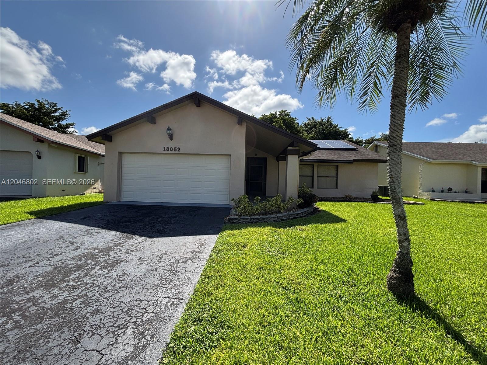 A single-story house with a garage, a driveway, and a palm tree in the front yard — 18052 S 105th Ave S # 18052, Boca Raton FL 33498, BOCA RATON, FL