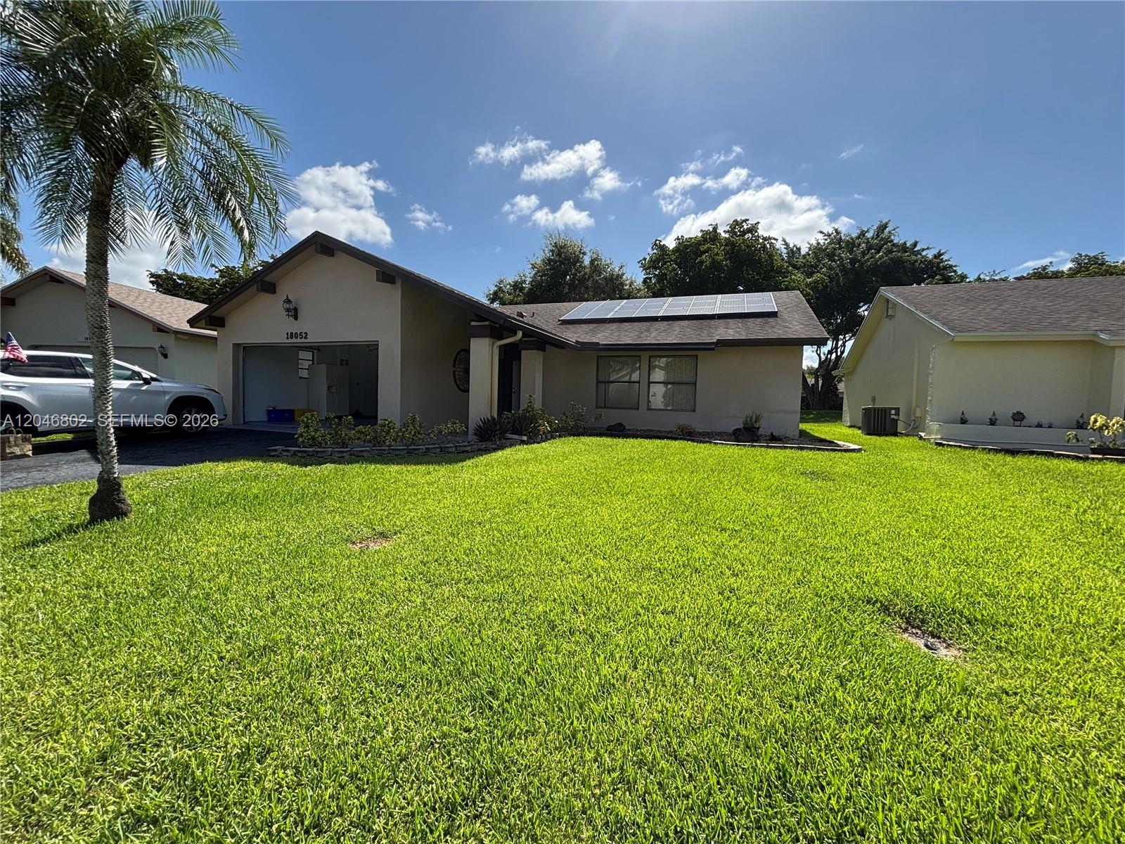 A single-story house with a garage, solar panels on the roof, and a front lawn — 18052 S 105th Ave S # 18052, Boca Raton FL 33498, BOCA RATON, FL