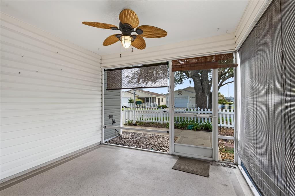 A screened-in porch features a ceiling fan, concrete flooring, and a view of a neighborhood — 16970 SE 94TH SUNNYBROOK CIRCLE, THE VILLAGES, FL