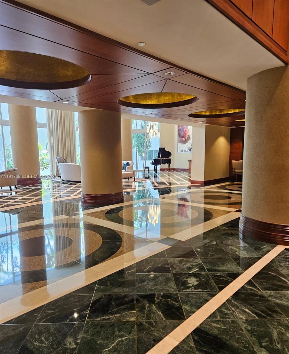A spacious lobby features polished marble floors, large cylindrical columns, and a grand piano — 21050 Point Pl # 501, Aventura FL 33180, AVENTURA, FL