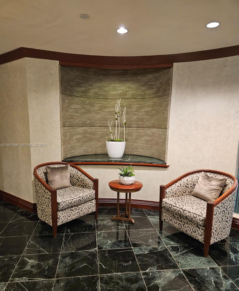 Two patterned armchairs sit on a dark marble floor before a recessed wall niche — 21050 Point Pl # 501, Aventura FL 33180, AVENTURA, FL