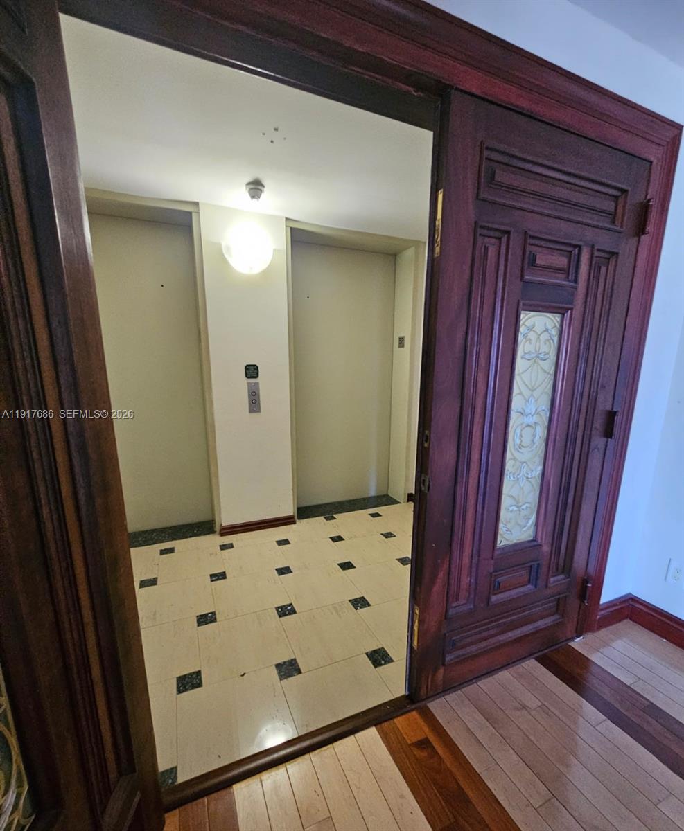 A view through an open wooden door reveals an elevator lobby with tiled floors — 21050 Point Pl # 501, Aventura FL 33180, AVENTURA, FL