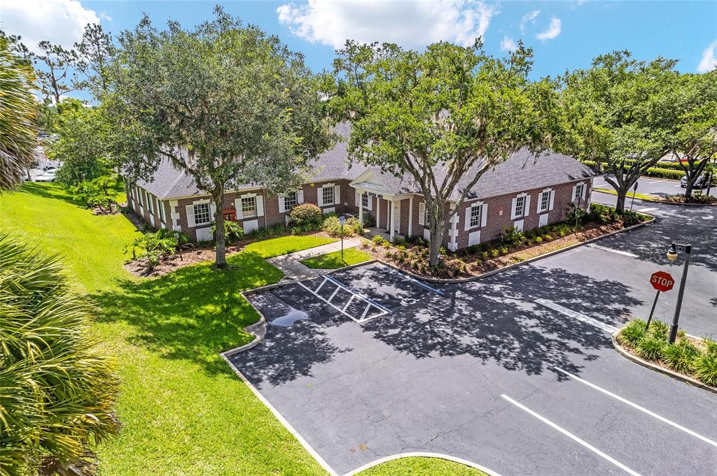 An exterior view of a single-story brick office building with a parking lot and trees — 301 SE 17TH STREET UNIT 2, OCALA, FL