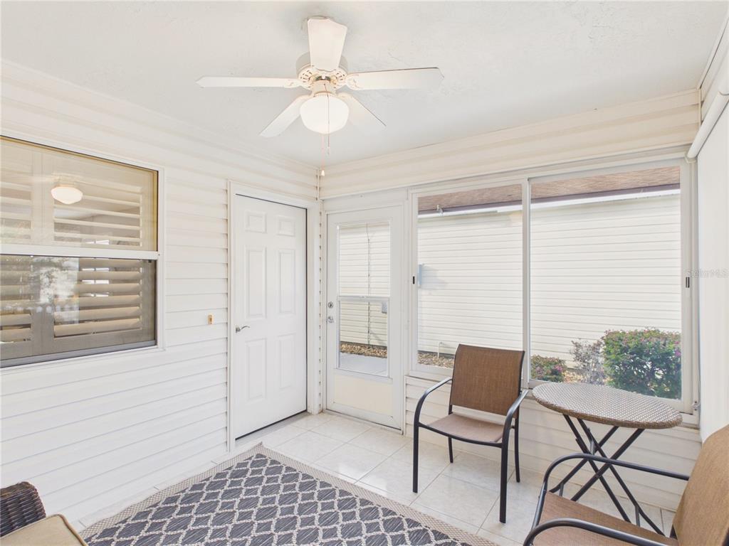 A sunroom features white walls, tile flooring, a ceiling fan, and a small bistro set — 746 ANGELITA AVE, THE VILLAGES, FL