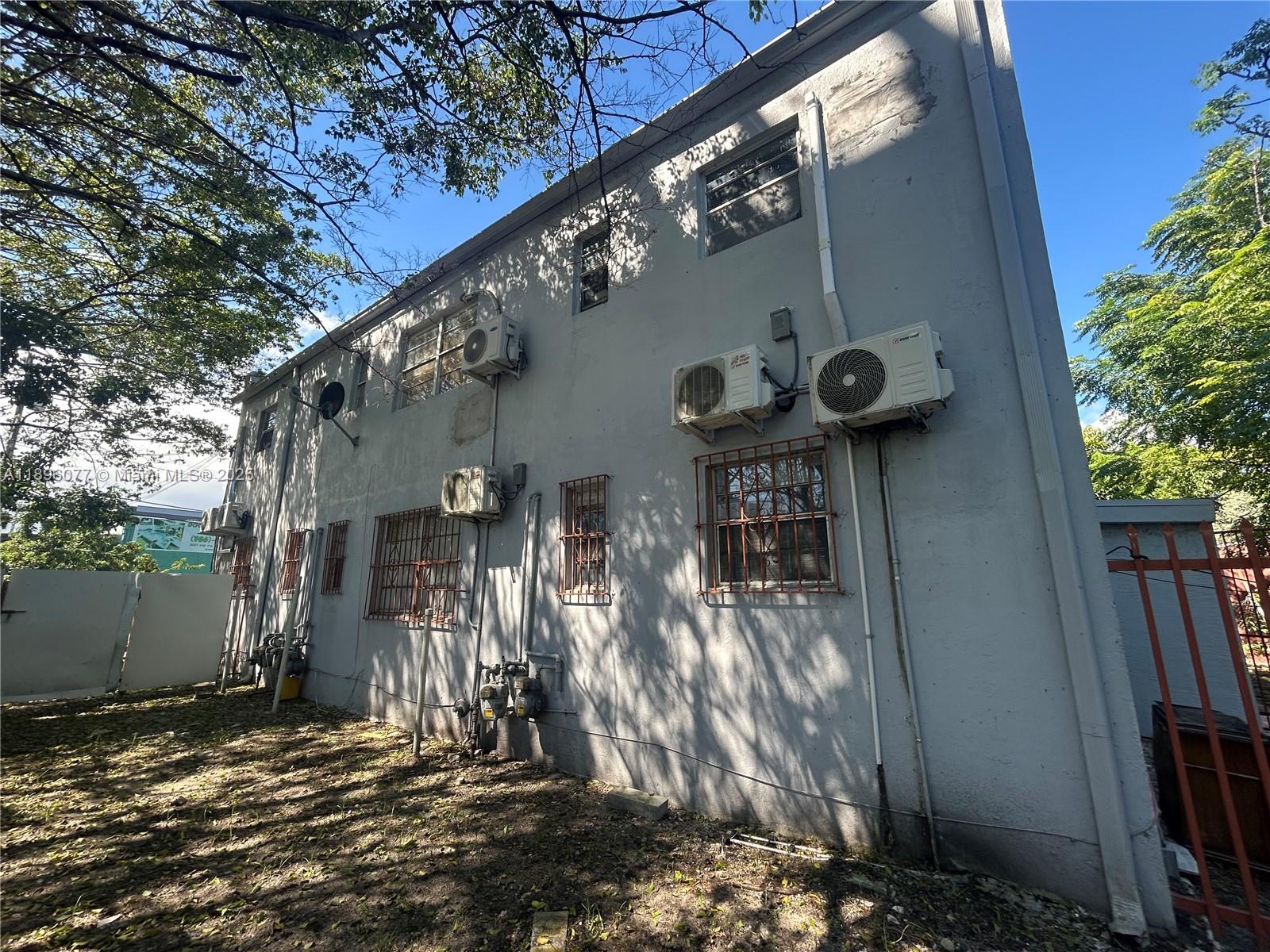 The exterior side of a two-story gray building features multiple wall-mounted air conditioning units — 2015 NW 6th Pl, Miami FL 33127, MIAMI, FL