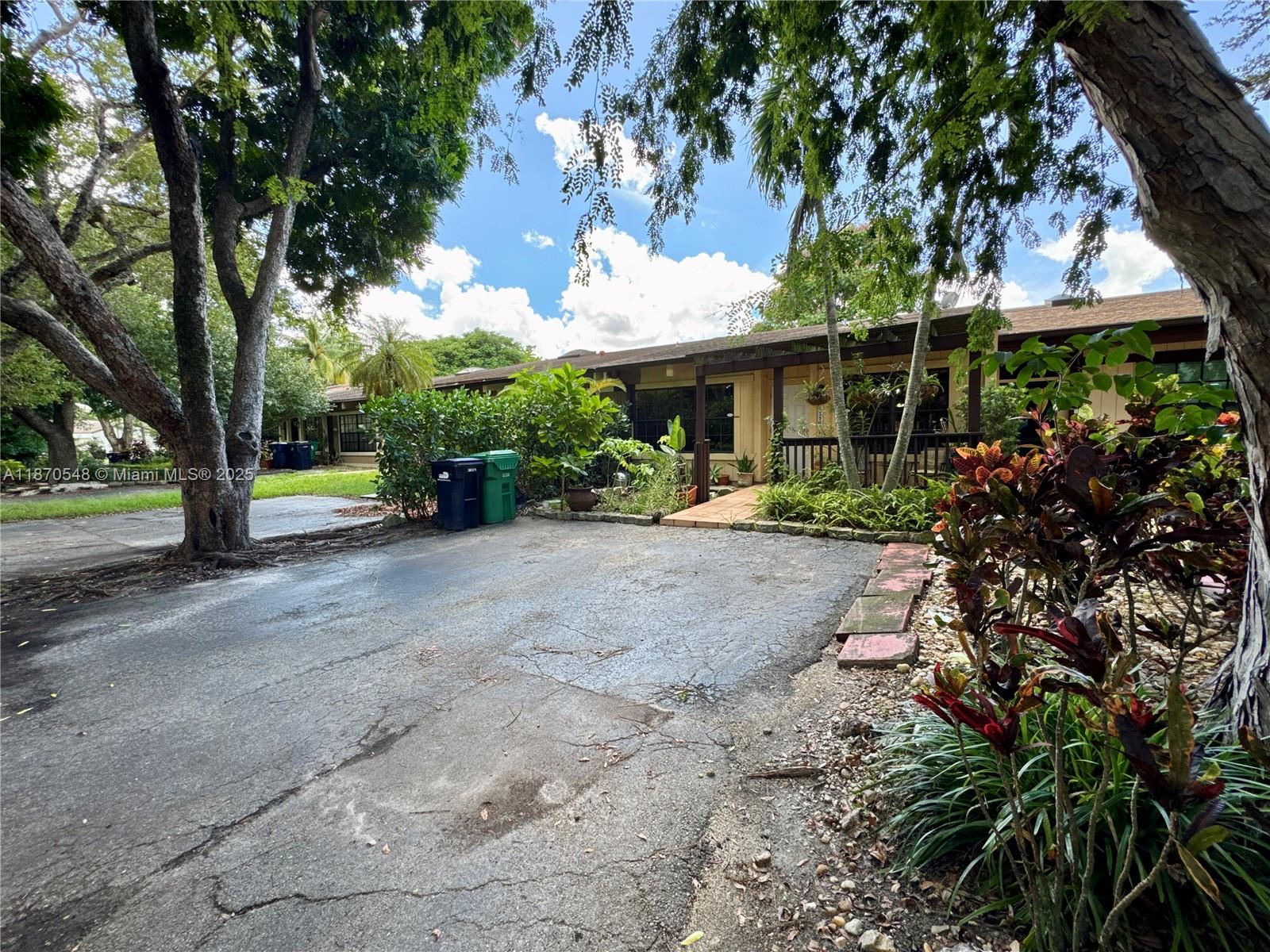 A paved driveway leads to the front entrance of a single-story house with landscaping — 13527 SW 101st Ln, Miami FL 33186, MIAMI, FL