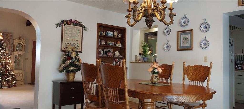 A dining room features a wooden table and chairs, a hutch, and a chandelier — 8943 SILVER LAKE DRIVE, LEESBURG, FL