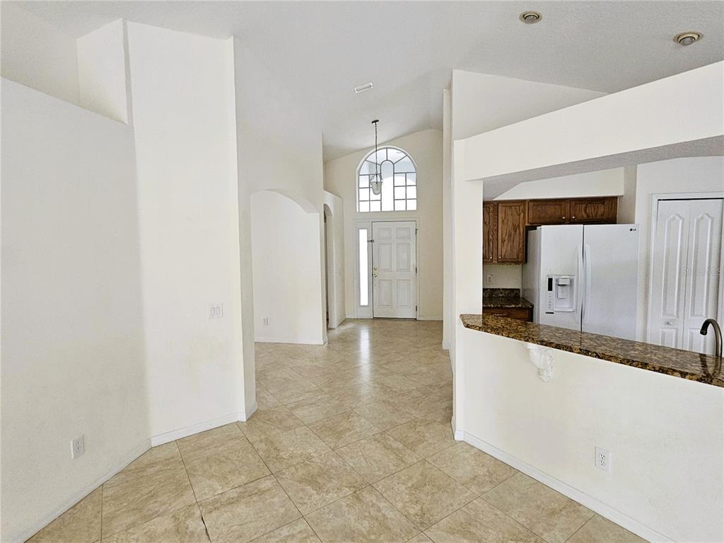 An interior view shows a tiled entryway leading to a front door with a transom window — 3220 CLOVER BLOSSOM CIRCLE, LAND O LAKES, FL