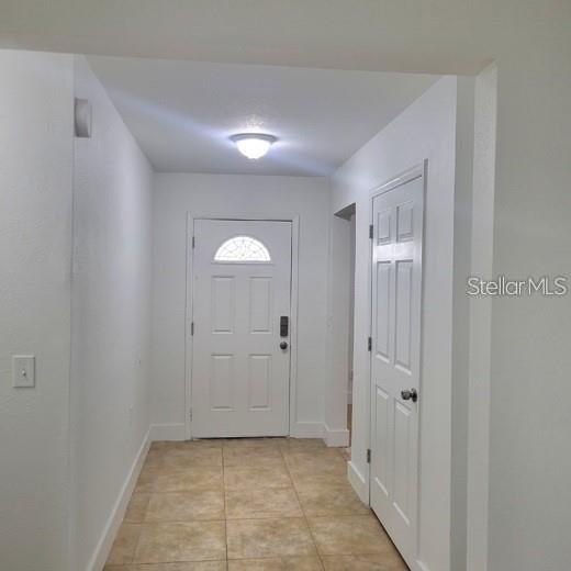 An entryway features a white front door, a closet door, and light-colored tile flooring — 605 HILLPOINT WAY, BRANDON, FL