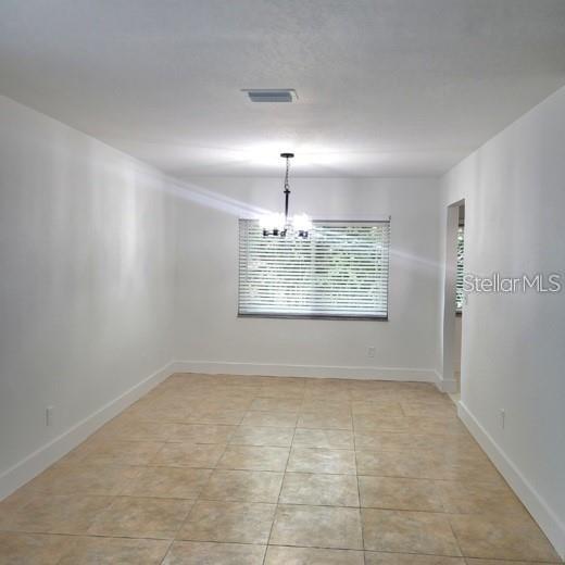 A dining room with white walls, tile flooring, a window with blinds, and a chandelier — 605 HILLPOINT WAY, BRANDON, FL