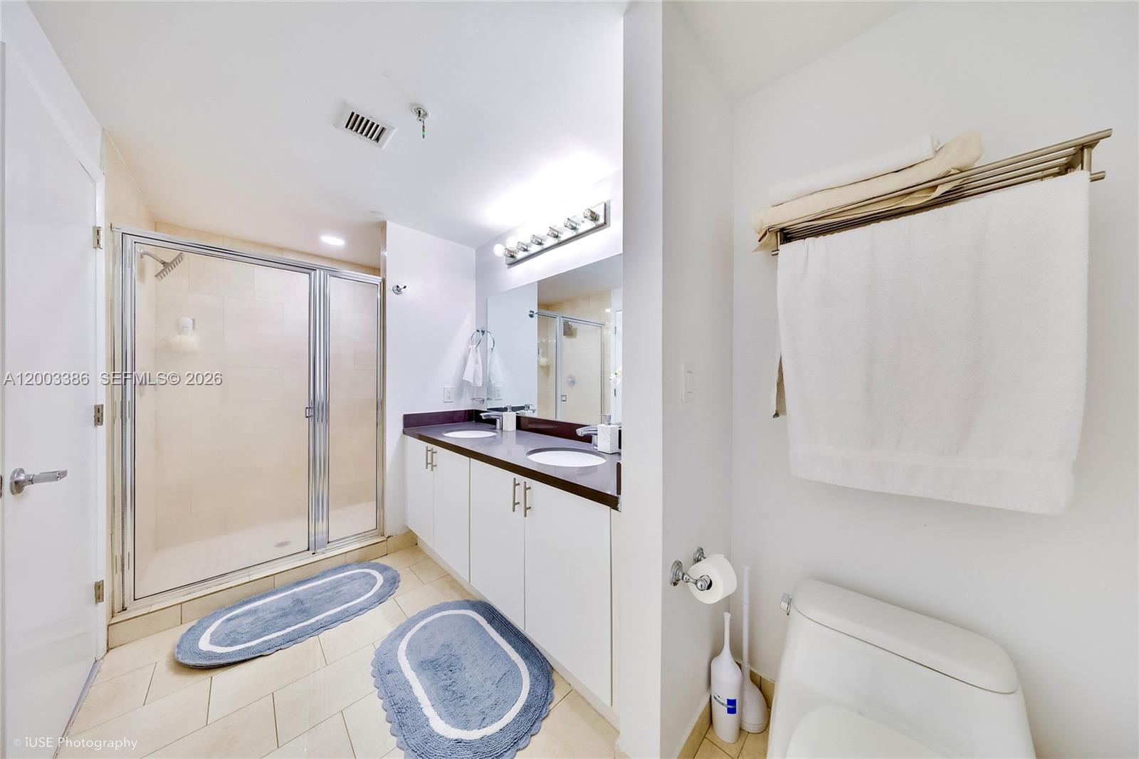 A bathroom features a glass-enclosed shower, a double-sink vanity, and a toilet — 90 SW 3rd St # 3109, Miami FL 33130, MIAMI, FL