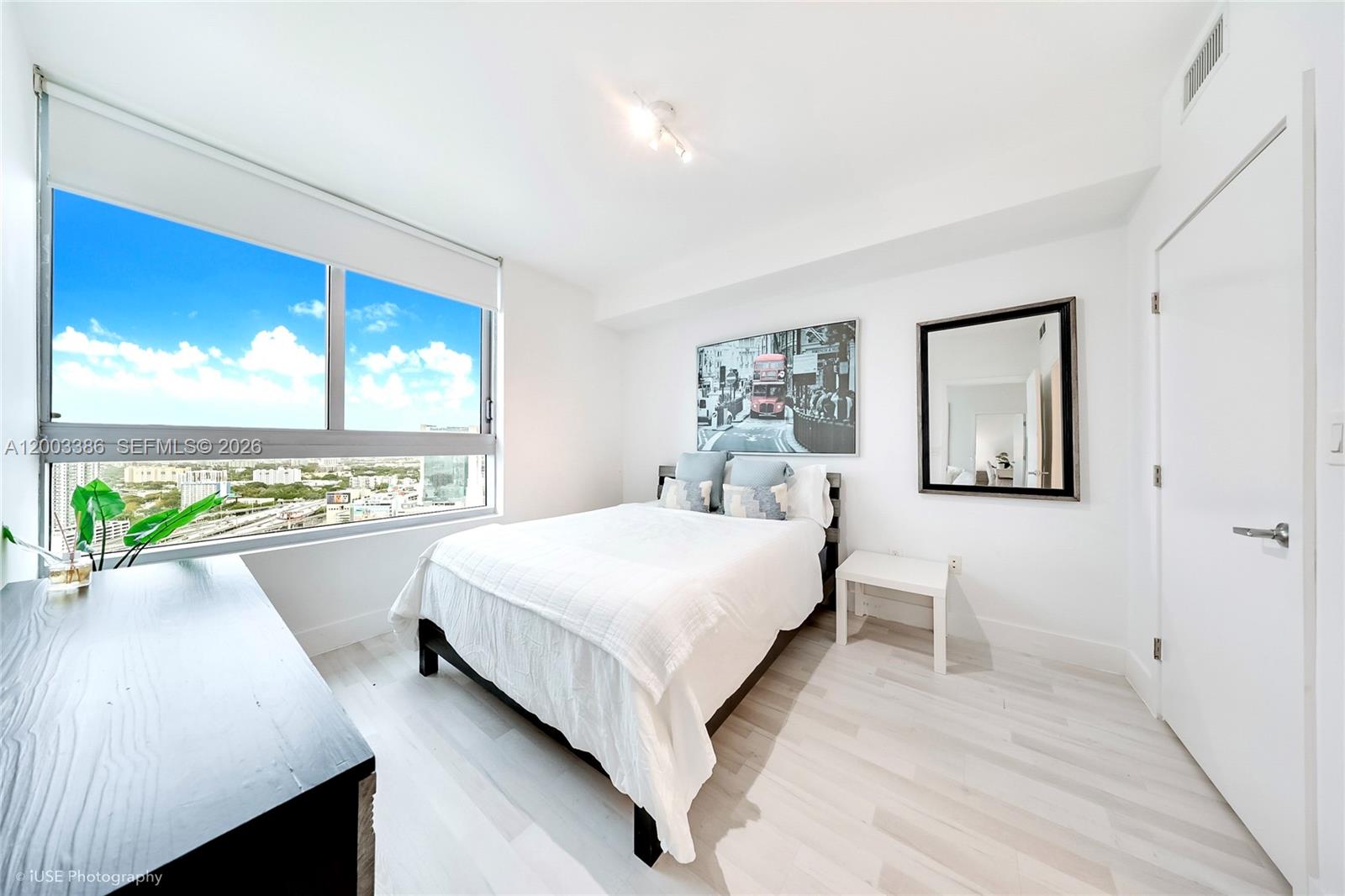A bedroom features a bed, a mirror, and a large window with a city view — 90 SW 3rd St # 3109, Miami FL 33130, MIAMI, FL