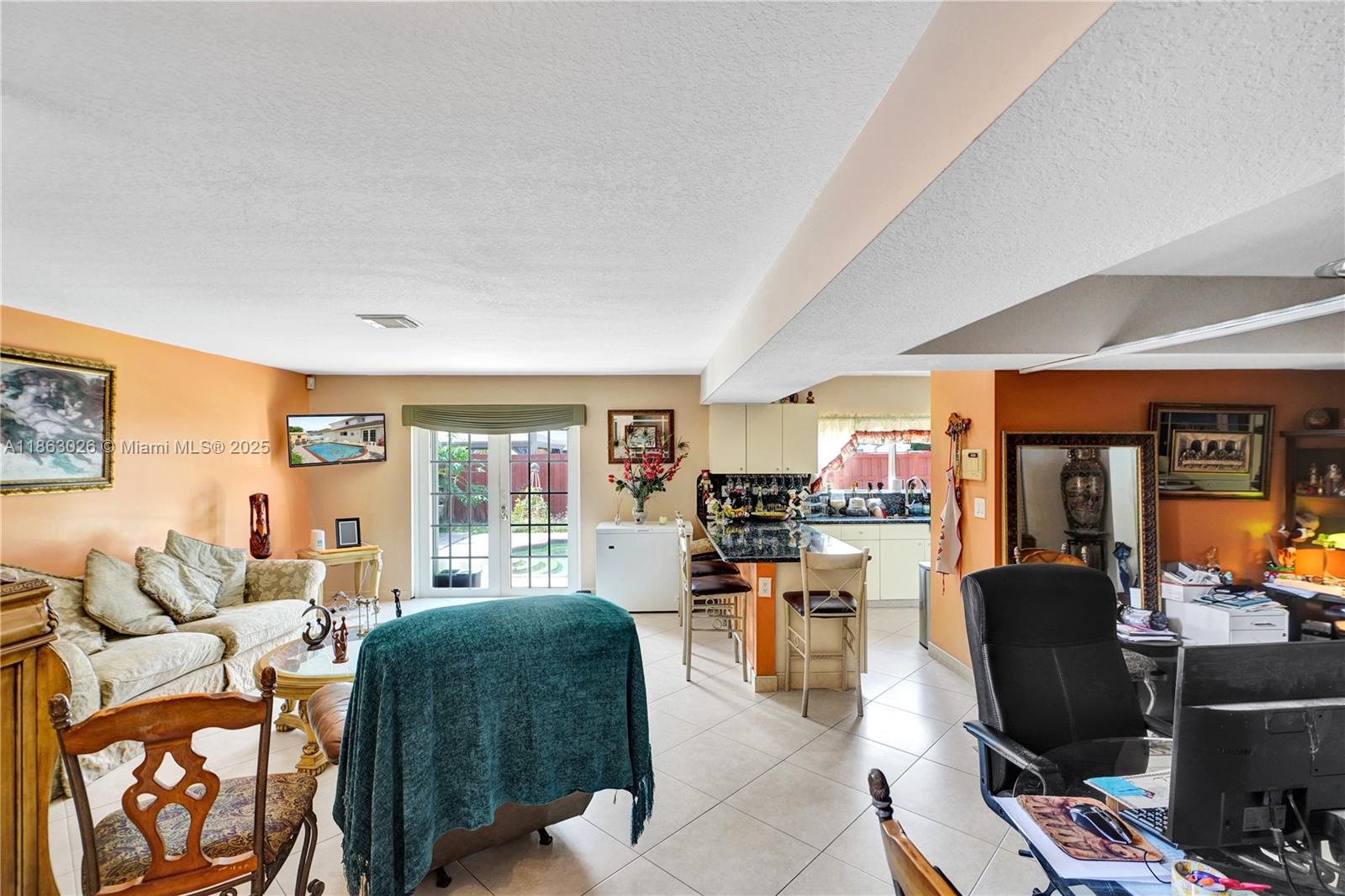 This open-concept living area features a kitchen with a breakfast bar and tile flooring — 14824 SW 180th St, Miami FL 33187, MIAMI, FL