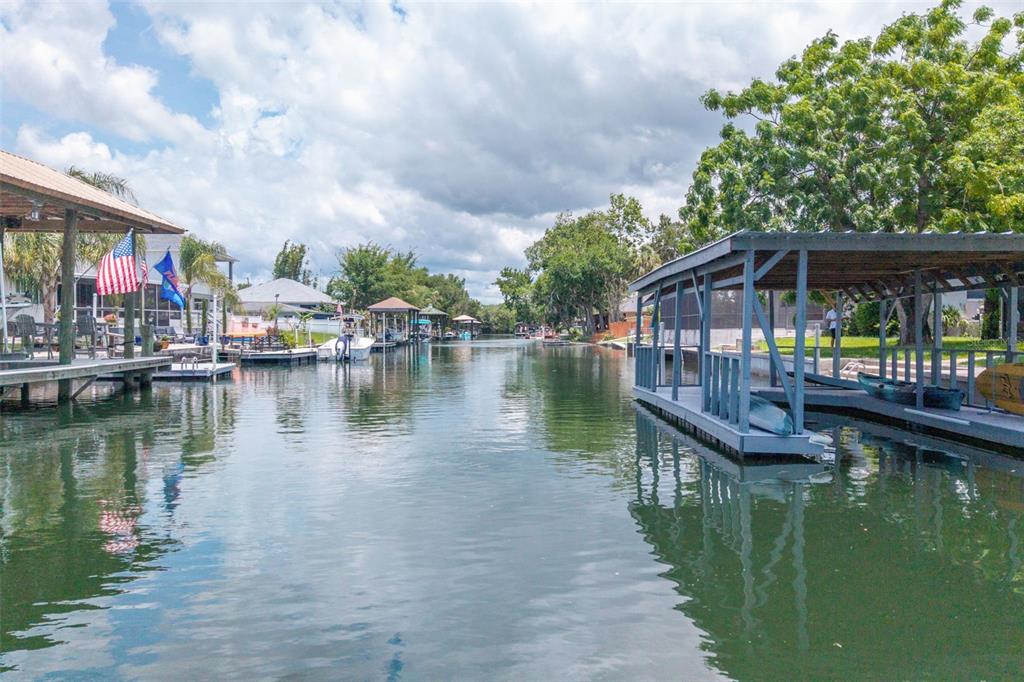 A canal view showing boat docks with covered slips and residential properties along the water — 1218 SE 5TH AVENUE, CRYSTAL RIVER, FL
