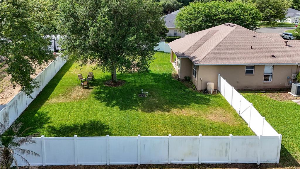 An aerial view shows a fenced backyard with a large tree and a house — 36806 WINFIELD COURT, GRAND ISLAND, FL