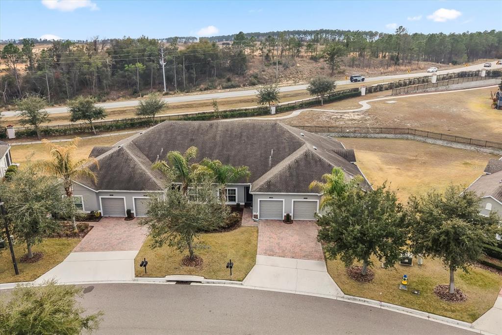 An aerial view shows a duplex home with two garages, brick driveways, and a large roof — 3538 FAIRWATERS COURT UNIT B, CLERMONT, FL