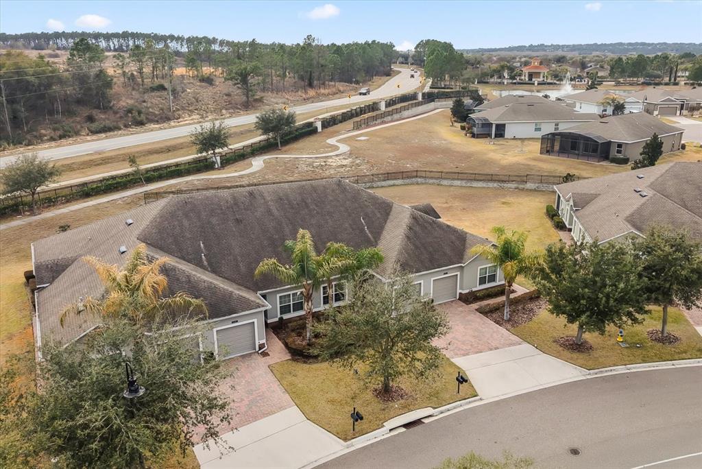 An aerial view shows a single-story house with a multi-car garage and a paved driveway — 3538 FAIRWATERS COURT UNIT B, CLERMONT, FL