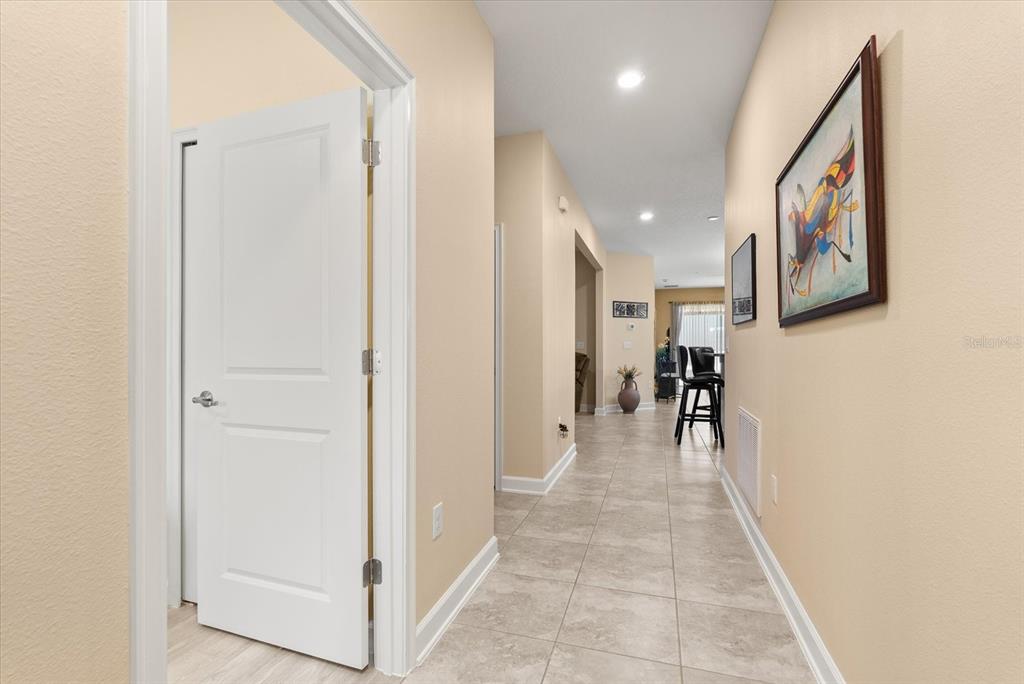 A tiled hallway leads from a doorway toward an open living area with bar stools — 3538 FAIRWATERS COURT UNIT B, CLERMONT, FL