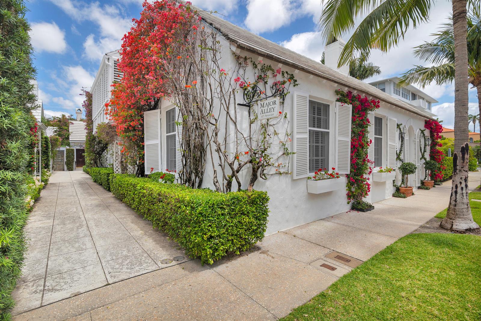 A white stucco building with red bougainvillea and a sign reading Major Alley — 417 Peruvian Avenue # 1, Palm Beach FL 33480, PALM BEACH, FL