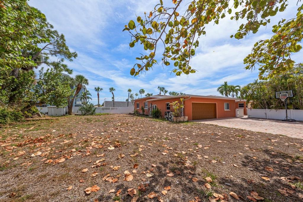 A single-story orange house with a garage and a large, leaf-covered yard — 630-650 79TH AVENUE, ST PETE BEACH, FL