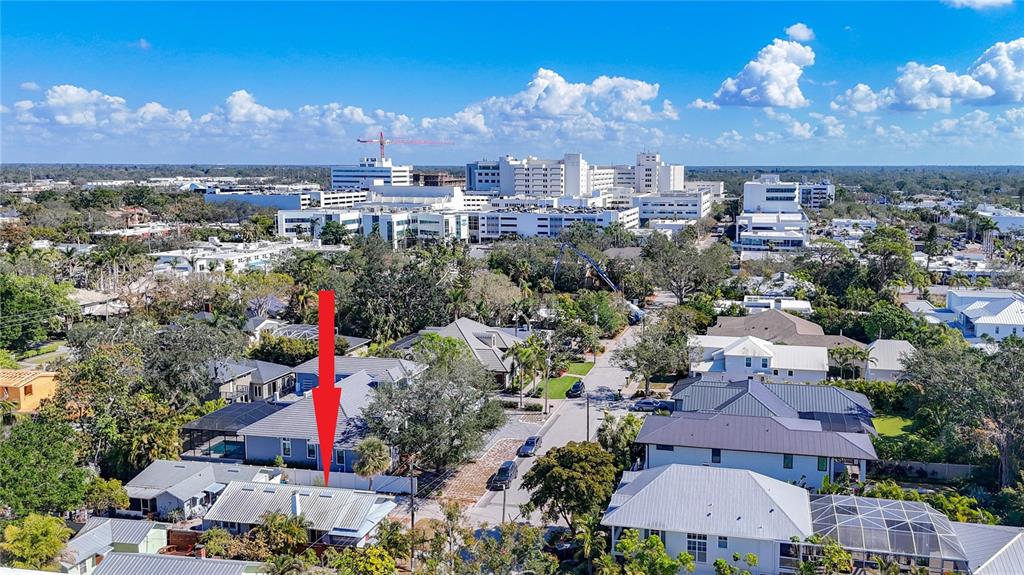 An aerial view shows a residential neighborhood with a red arrow pointing to a house — 1687 ARLINGTON STREET, SARASOTA, FL