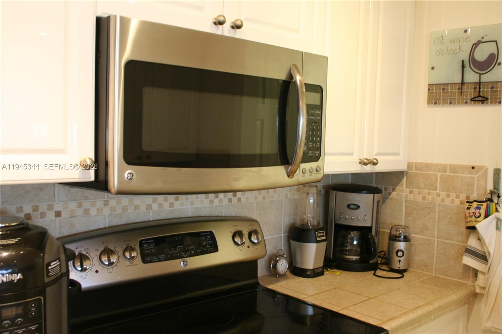 A kitchen features white cabinets, a stainless steel microwave, and a black electric range — 104500 Overseas Hwy # A302, Key Largo FL 33037, KEY LARGO, FL